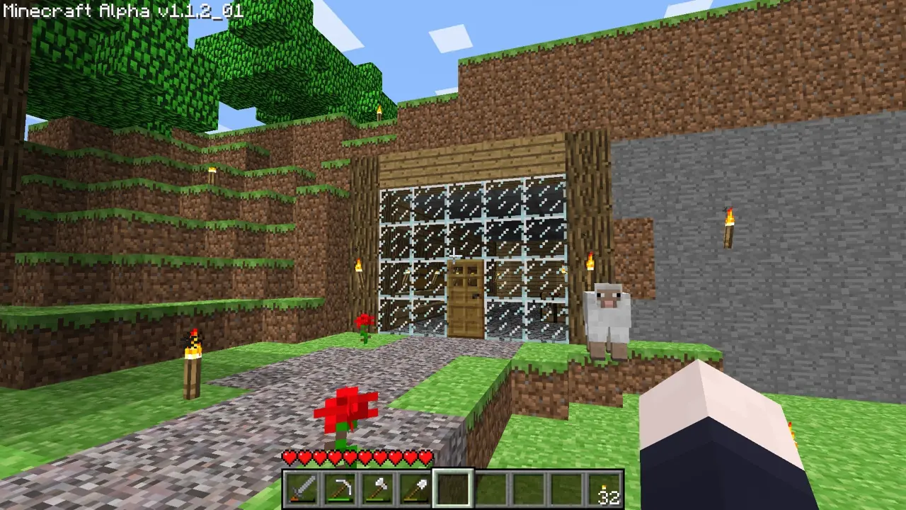 An image of Minecraft, with the text Minecraft Alpha v1.1.2_01 in the top left. There is a landscape with a hill in front of the camera. The hill contains a base with walls of glass and oak logs on the side. There is a path leading up to the base, which has roses around it. A sheep is next to the base.